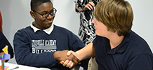 two TTA male students shaking hands